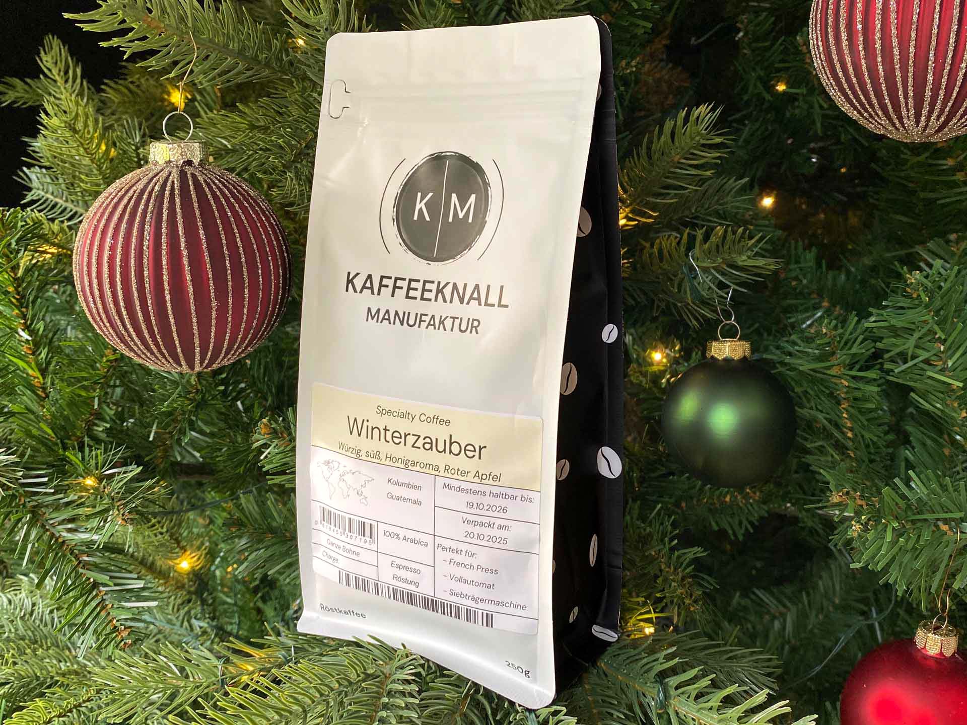 Winterzauber Kaffee von Kaffeeknall – Seitenansicht der weißen Kaffeepackung im Weihnachtsbaum